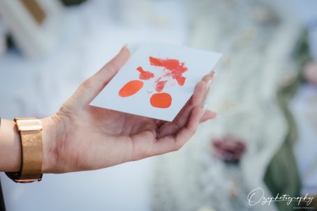 Eine Hand hält eine Karte mit einem orangefarbenen, illustrativen Design.
