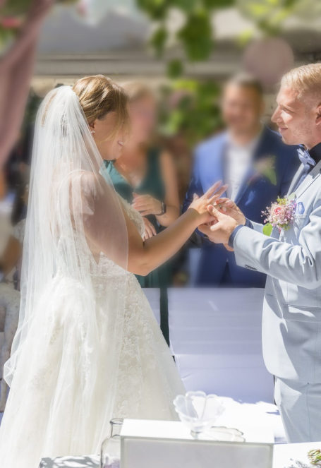 Braut und Bräutigam tauschen Ringe während der Hochzeitszeremonie im Freien.