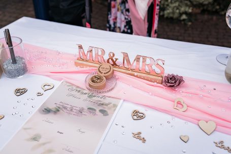Dekoration mit "MR & MRS" Schriftzug auf einem gedeckten Tisch für eine Hochzeit.