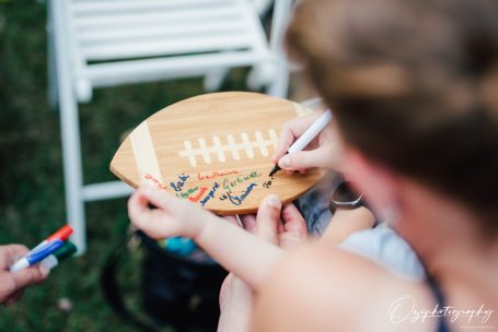 Holzplatte in Form eines Footballs mit bunten Schriftzügen und Unterschriften.