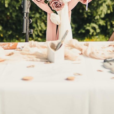 Ein festlich gedeckter Tisch mit rosa Rosen und dekorativen Elementen.